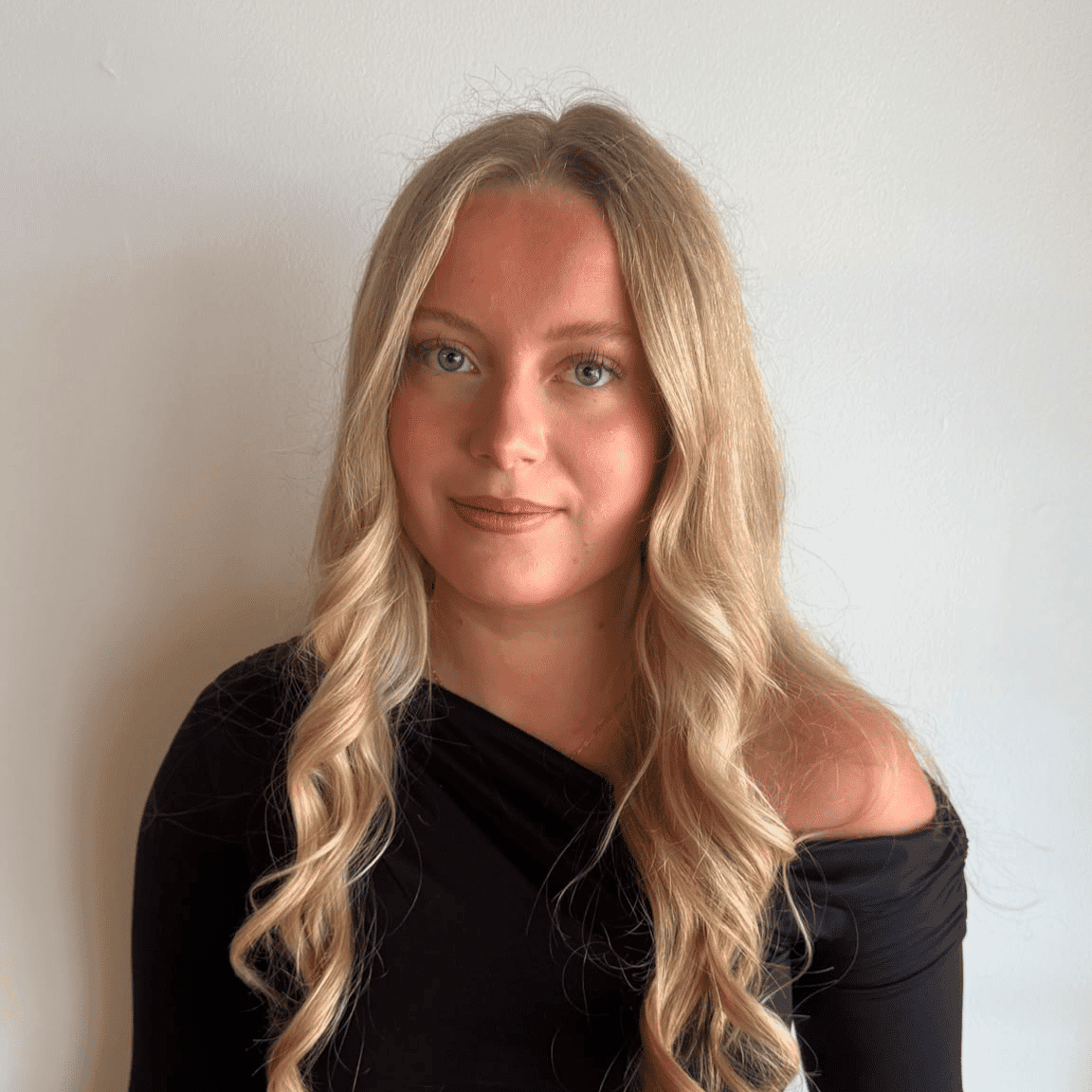 Portrait of Izzy Chmarney, a professional stylist at Raven Hair Co., showcasing their expertise and style.