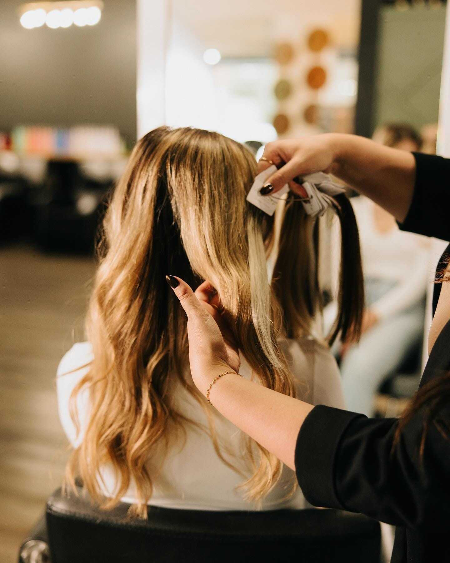 Hairdresser applying foils to client's hair in a salon.