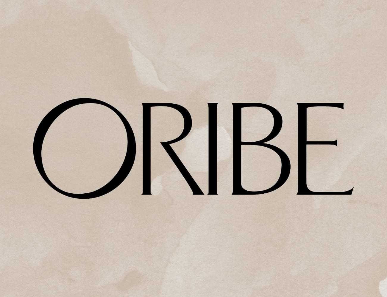 Oribe logo on a beige textured background.